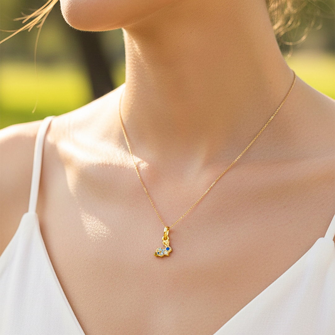 Cuello de modelo usando una cadena con un dije en forma de conejo en oro amarillo de 18 quilates con cristales de Joyería Caracas.