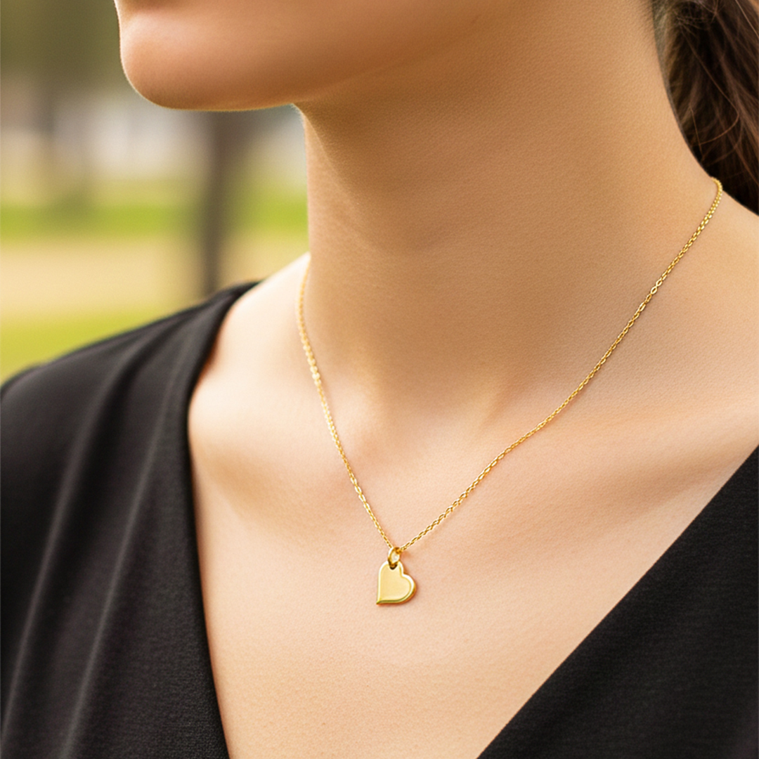 Cuello de modelo usando una cadena con un dije en forma de corazón en oro amarillo de 18 quilates de Joyería Caracas.