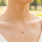 Cuello de modelo usando una cadena con un dije en forma de corazón en oro amarillo de 18 quilates con cristales de Joyería Caracas.