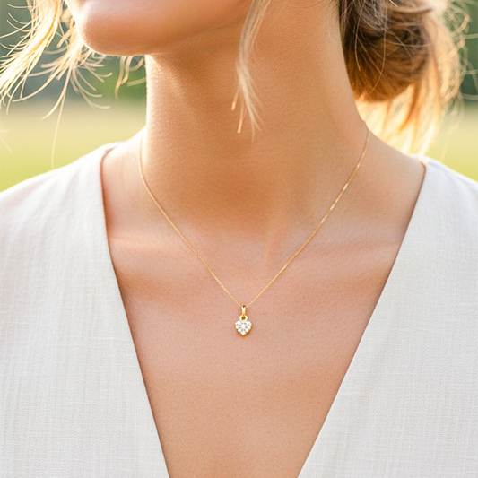 Cuello de modelo usando una cadena con un dije en forma de corazón oro amarillo de 18 quilates con cristales de Joyería Caracas.