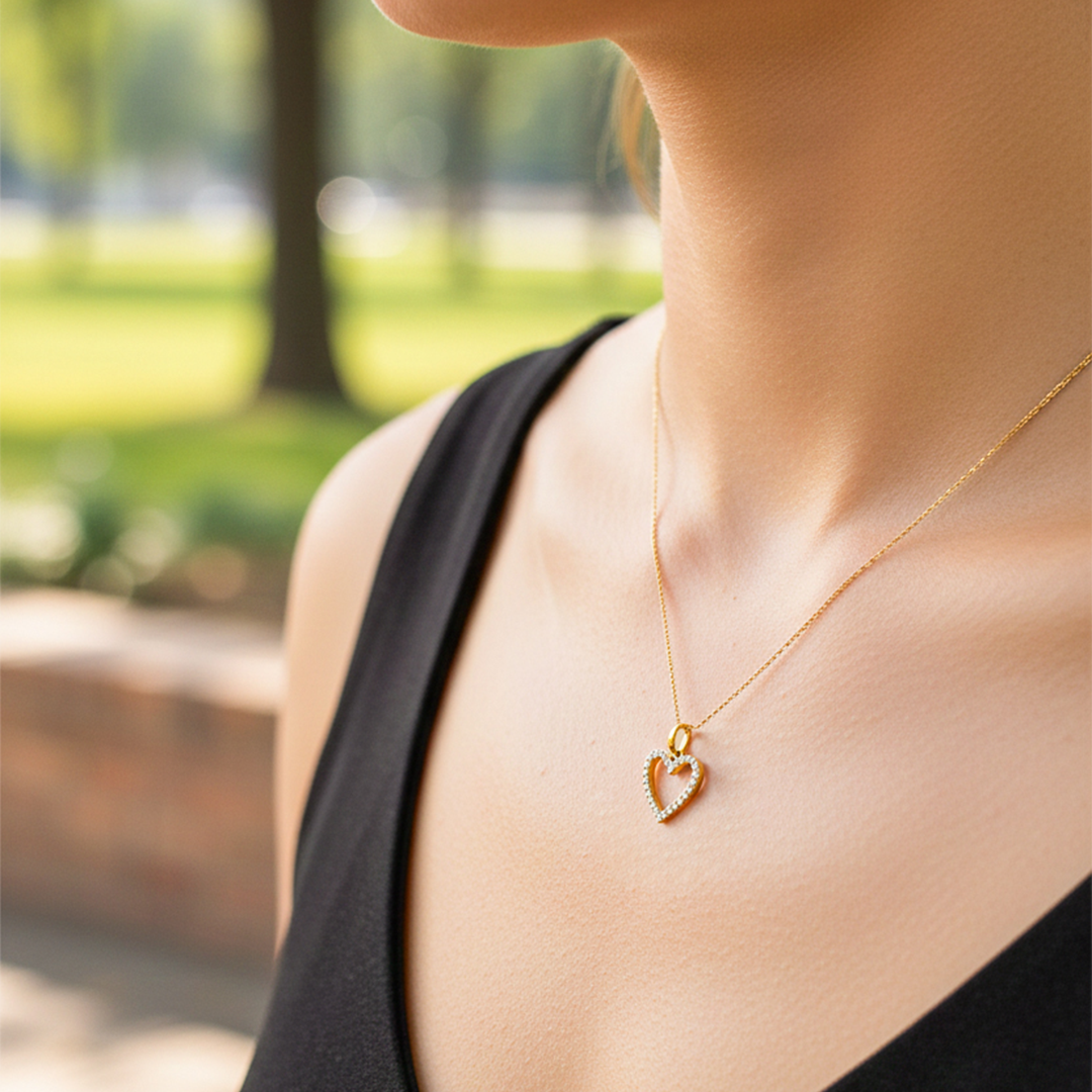 Cuello de modelo usando una cadena con un dije en forma de corazón en oro amarillo de 18 quilates con cristales de Joyería Caracas.