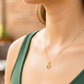 Cuello de modelo usando una cadena con un dije en forma de corazón con angelito en oro amarillo de 18 quilates con cristales de Joyería Caracas.