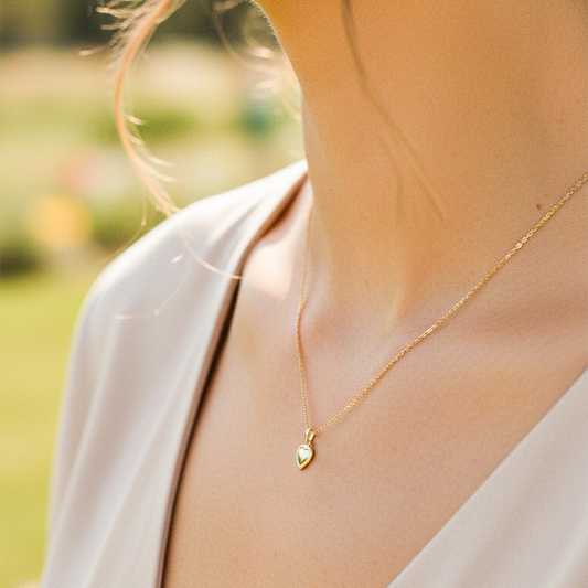 Cuello de modelo usando una cadena con un dije en forma de corazón en oro amarillo de 18 quilates de Joyería Caracas.
