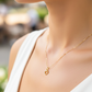 Cuello de modelo usando una cadena con un dije en forma de corazón en oro amarillo de 18 quilates con cristales de Joyería Caracas.