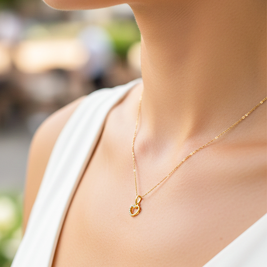 Cuello de modelo usando una cadena con un dije en forma de corazón en oro amarillo de 18 quilates con cristales de Joyería Caracas.