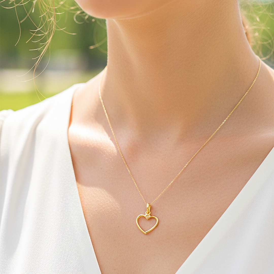 Cuello de modelo usando una cadena con un dije en forma de la silueta de corazón oro amarillo de 18 quilates de Joyería Caracas.