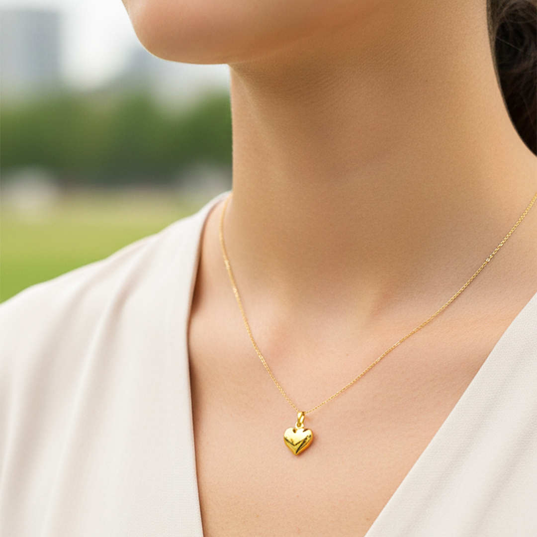 Cuello de modelo usando una cadena con un dije en forma de corazón soplado oro amarillo de 18 quilates de Joyería Caracas.