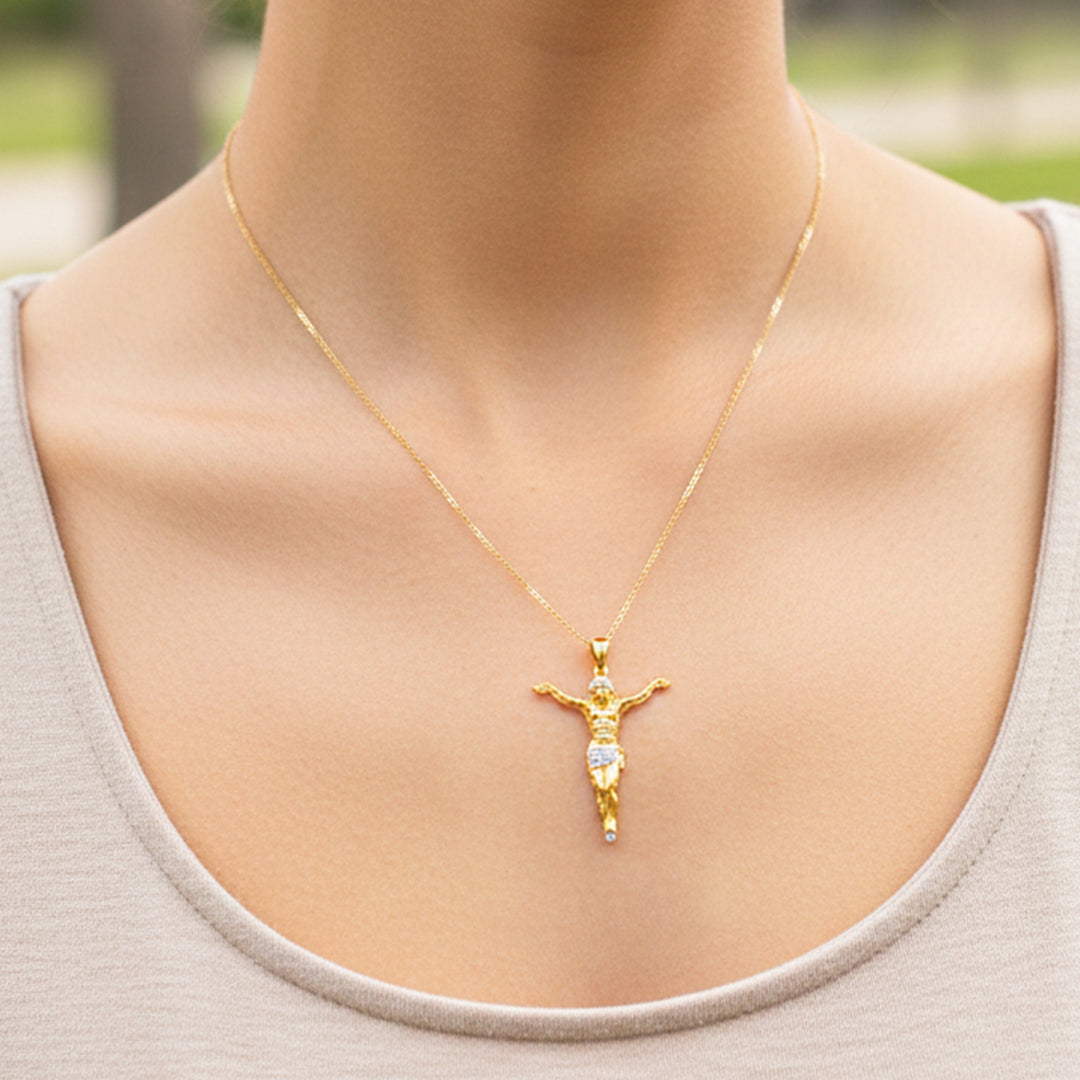 Cuello de modelo usando una cadena con un dije en forma de Cristo en oro amarillo y blanco de 18 quilates de Joyería Caracas.