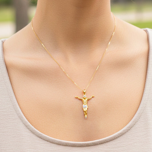 Cuello de modelo usando una cadena con un dije en forma de Cristo en oro amarillo y blanco de 18 quilates de Joyería Caracas.