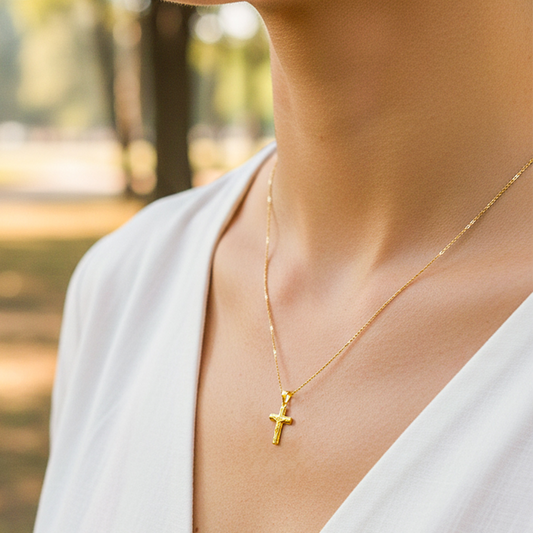 Cuello de modelo usando una cadena con un dije en forma de Cristo en oro amarillo de 18 quilates de Joyería Caracas.