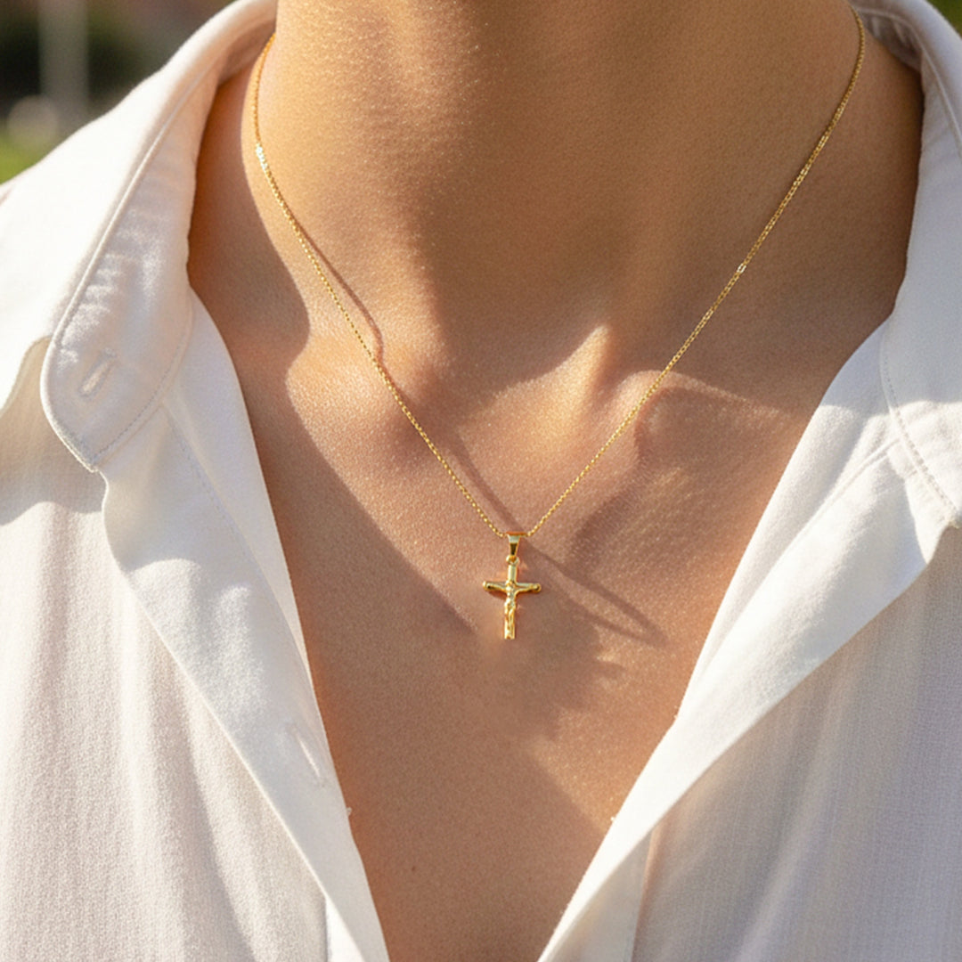 Cuello de modelo usando una cadena con un dije en forma de Cruz con Cristo en oro amarillo de 18 quilates de Joyería Caracas.