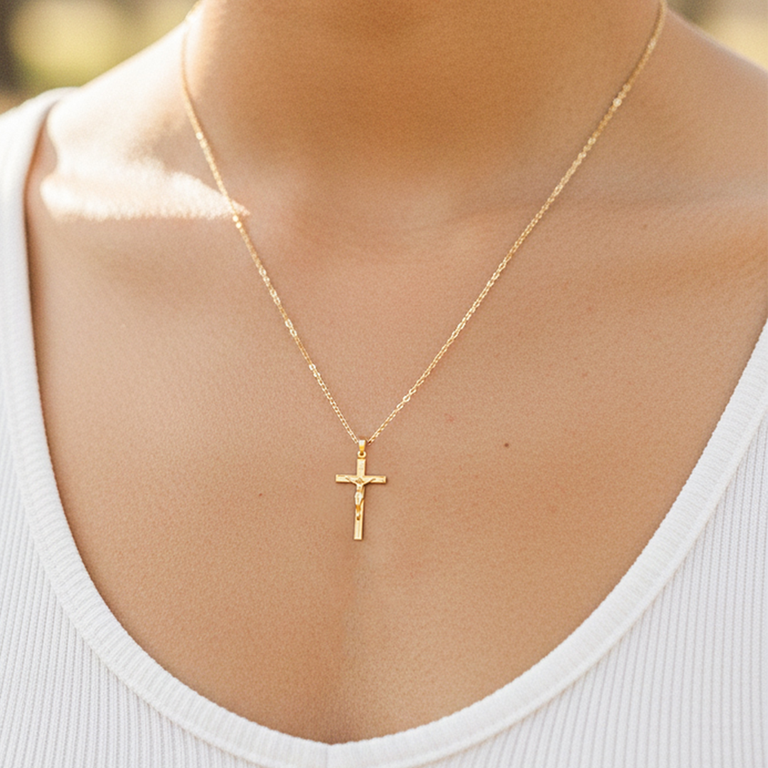 Cuello de modelo usando una cadena con un dije en forma de Cruz con Cristo en oro amarillo de 18 quilates de Joyería Caracas.