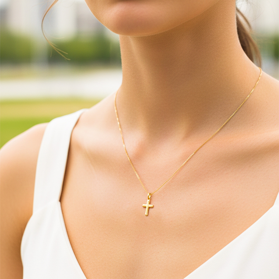 Cuello de modelo usando una cadena con un dije en forma de Cruz en oro amarillo de 18 quilates de Joyería Caracas.