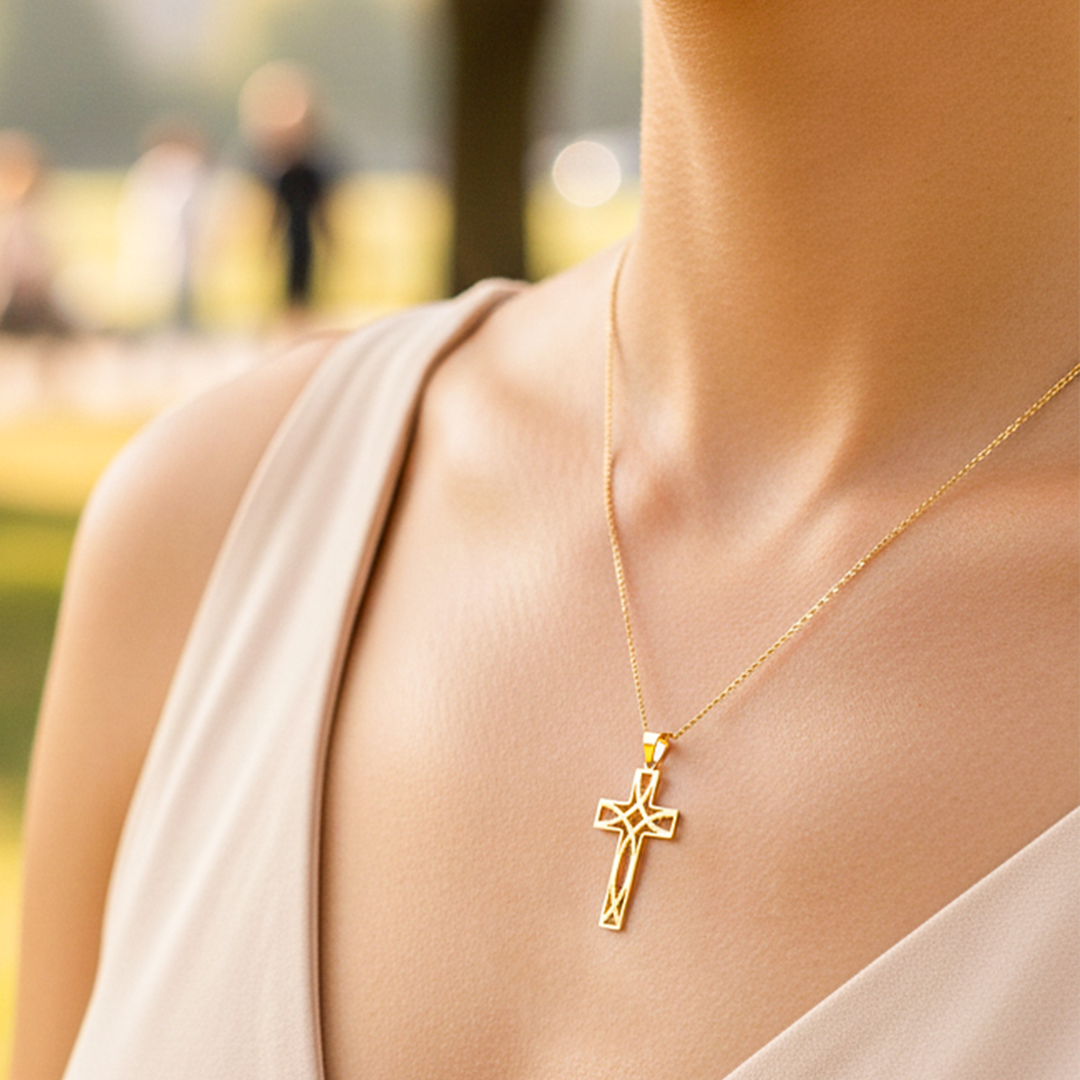 Cuello de modelo usando una cadena con un dije en forma de cruz simétrica en oro amarillo de 18 quilates de Joyería Caracas.