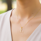 Cuello de modelo usando una cadena con un dije en forma de Cruz aurea diamantada en oro amarillo de 18 quilates de Joyería Caracas.