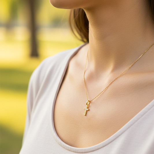 Cuello de modelo usando una cadena con un dije en forma de Cruz en oro amarillo de 18 quilates con cristales de Joyería Caracas.