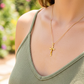 Cuello de modelo usando una cadena con un dije en forma de Cruz clásica en oro amarillo de 18 quilates de Joyería Caracas.