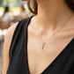 Cuello de modelo usando una cadena con un dije cruz en oro amarillo de 18 quilates con cristales de Joyería Caracas.