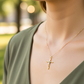 Cuello de modelo usando una cadena con un dije en forma de cruz con Cristo en oro amarillo y blanco de 18 quilates de Joyería Caracas.