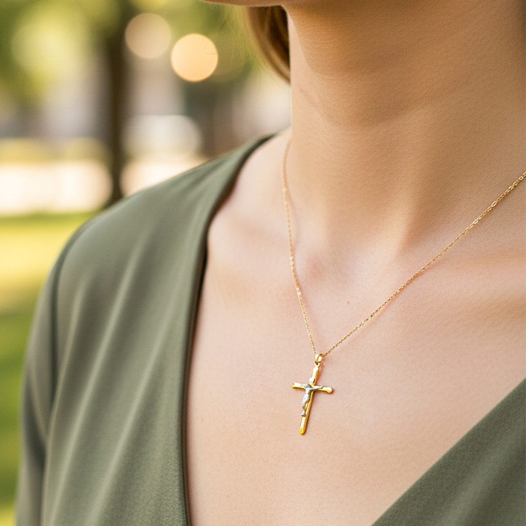 Cuello de modelo usando una cadena con un dije en forma de cruz con Cristo en oro amarillo y blanco de 18 quilates de Joyería Caracas.