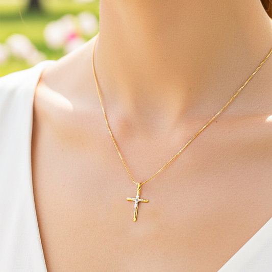 Cuello de modelo usando una cadena con un dije en forma de Cruz con Cristo en oro amarillo y blanco de 18 quilates de Joyería Caracas.