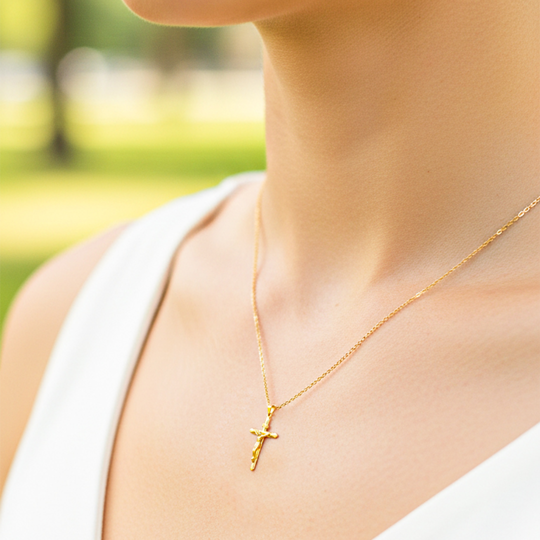 Cuello de modelo usando una cadena con un dije en forma de Cruz con Cristo en oro amarillo de 18 quilates de Joyería Caracas.