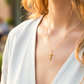 Cuello de modelo usando una cadena con un dije en forma de Cruz con Cristo de medio tubo en oro amarillo de 18 quilates de Joyería Caracas.