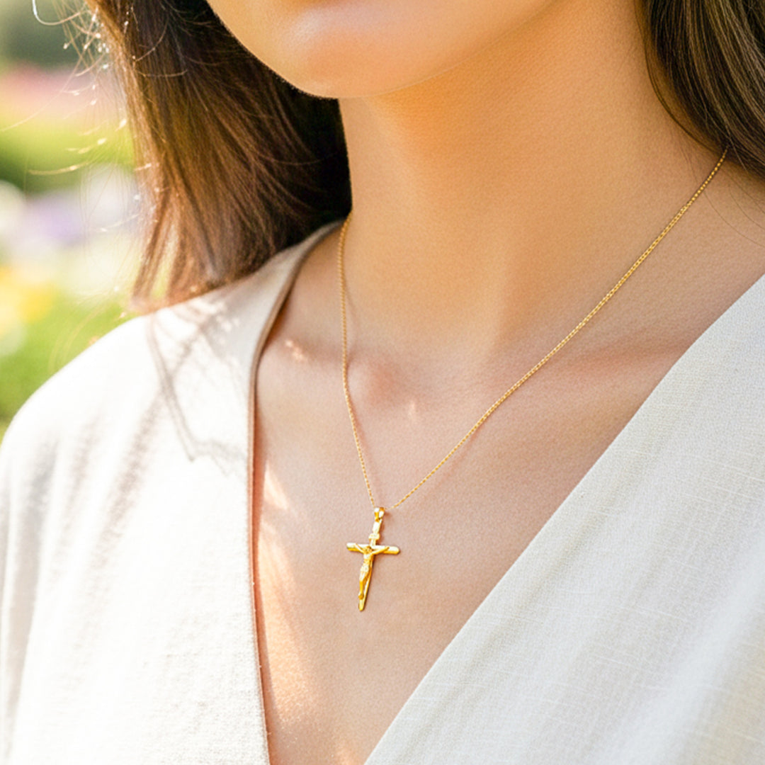 Cuello de modelo usando una cadena con un dije en forma de Cruz con Cristo en oro amarillo de 18 quilates de Joyería Caracas.