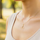 Cuello de modelo usando una cadena con un dije en forma de Cruz con Cristo en oro amarillo y blanco de 18 quilates de Joyería Caracas.