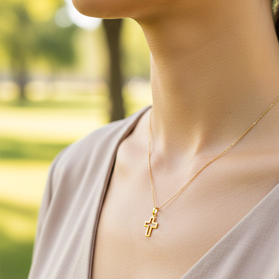 Cuello de modelo usando una cadena con un dije en forma del croquis de una cruz en oro amarillo de 18 quilates de Joyería Caracas.
