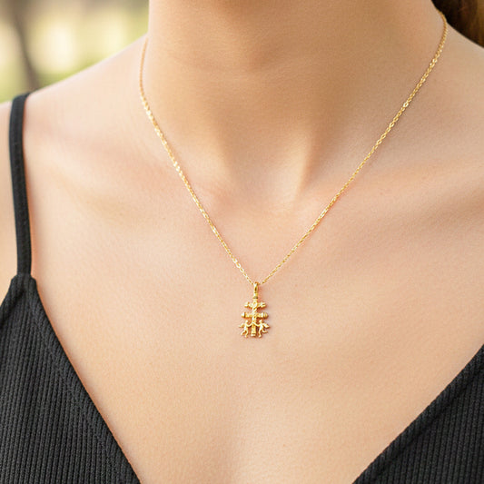 Cuello de modelo usando una cadena con un dije en forma de Cruz de Caravaca en oro amarillo de 18 quilates de Joyería Caracas.