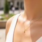 Cuello de modelo usando una cadena con un dije en forma de corazón soplado en oro amarillo de 18 quilates con cristal de Joyería Caracas.