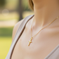 Cuello de modelo usando una cadena con un dije en forma de Cruz de tubo en oro amarillo de 18 quilates de Joyería Caracas.