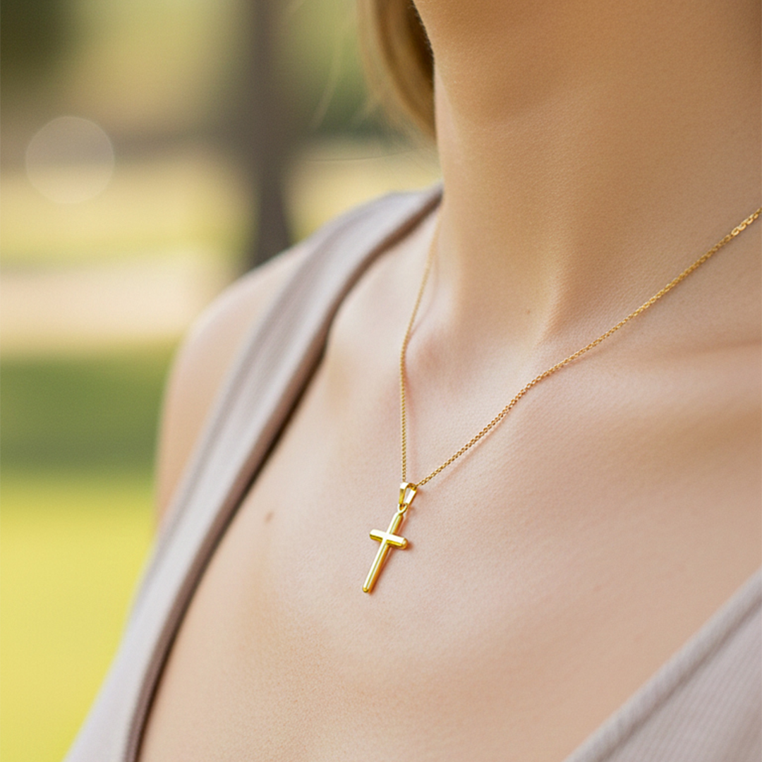 Cuello de modelo usando una cadena con un dije en forma de Cruz de tubo en oro amarillo de 18 quilates de Joyería Caracas.