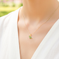 Cuello de modelo usando una cadena con un dije en forma de Dinosaurio en oro amarillo de 18 quilates con cristales de color verde de Joyería Caracas.