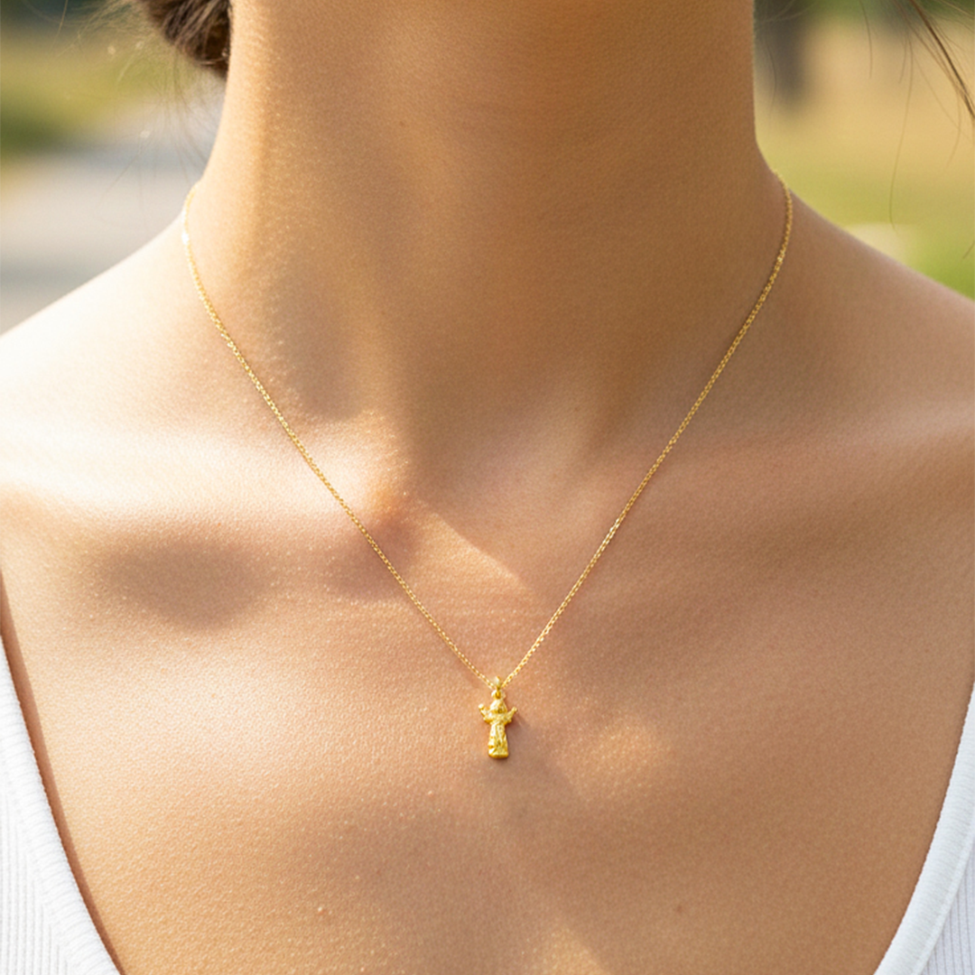 Cuello de modelo usando una cadena con un dije en forma de Divino Niño en oro amarillo de 18 quilates de Joyería Caracas.