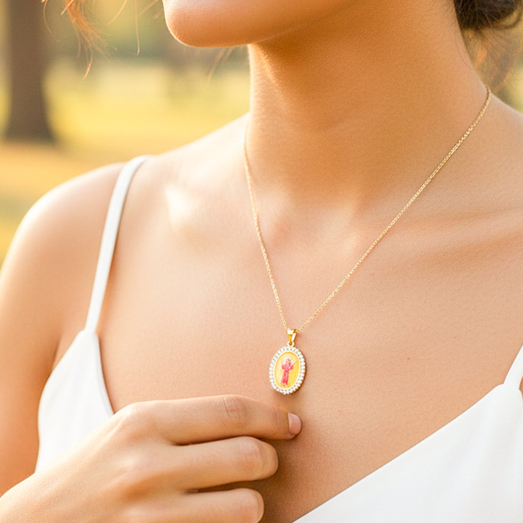 Cuello de modelo usando una cadena con un dije del Divino Niño a color y en oro amarillo de 18 quilates de Joyería Caracas.