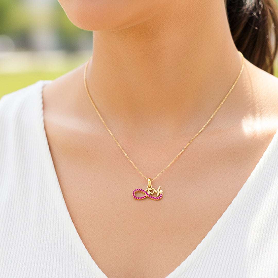 Cuello de modelo usando una cadena con un dije en forma de infinito en oro amarillo de 18 quilates con cristales rosas de Joyería Caracas.