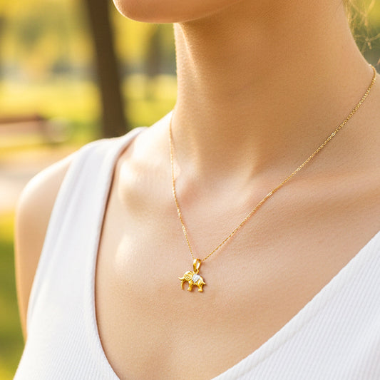 Cuello de modelo usando una cadena con un dije en forma de elefante sagrado en oro amarillo y blanco de 18 quilates de Joyería Caracas.
