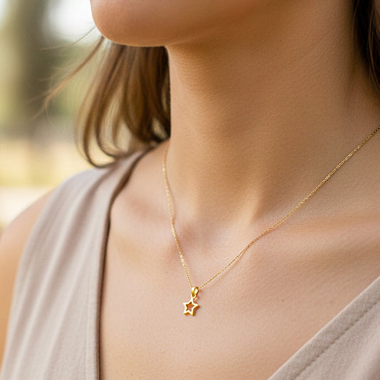 Cuello de modelo usando una cadena con un dije en forma de estrella calada en oro amarillo de 18 quilates de Joyería Caracas.