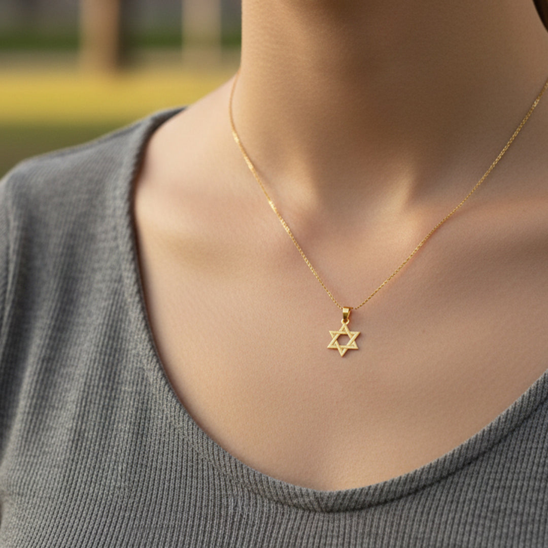 Cuello de modelo usando una cadena con un dije en forma de estrella de David en oro amarillo de 18 quilates de Joyería Caracas.