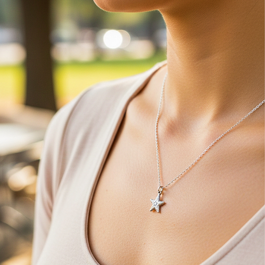 Cuello de modelo usando una cadena con un dije en forma de estrella en oro blanco de 18 quilates de Joyería Caracas.