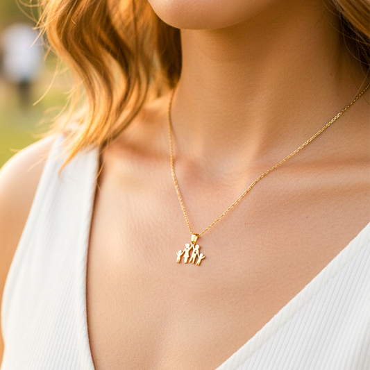 Cuello de modelo usando una cadena con un dije en forma de familia en oro amarillo de 18 quilates de Joyería Caracas.
