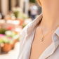 Cuello de modelo usando una cadena con un dije en forma de flor en oro amarillo de 18 quilates con cristales de Joyería Caracas.