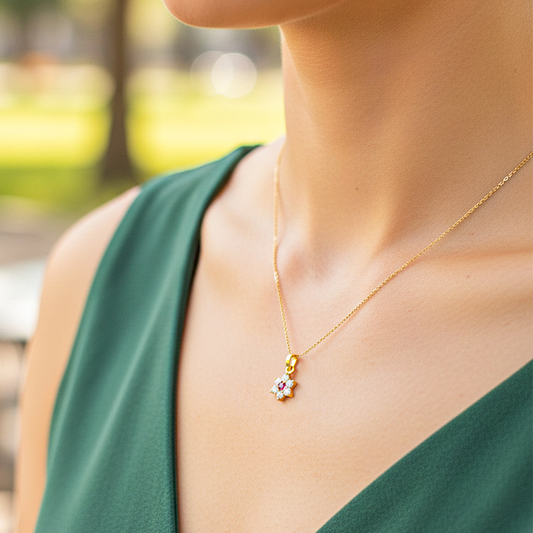 Cuello de modelo usando una cadena con un dije en forma de flor en oro amarillo de 18 quilates con cristales de Joyería Caracas.