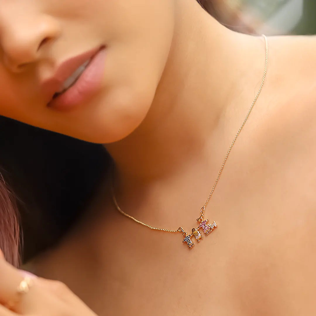 Cuello de mujer usando una gargantilla con dije de familia con un perro en oro amarillo de 18 quilates y cristales de color azul, rosa y blanco de Joyería Caracas. 