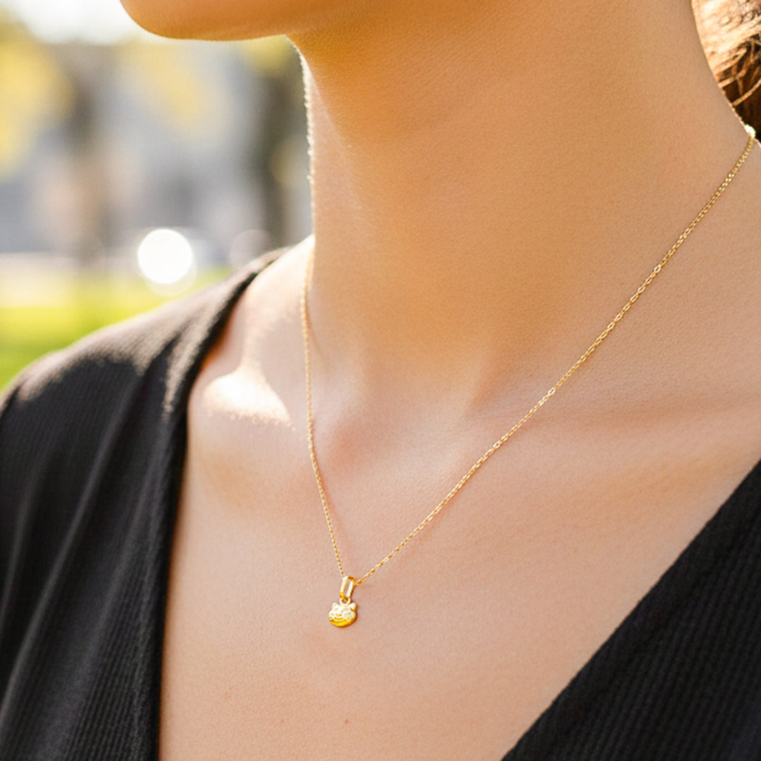 Cuello de modelo usando una cadena con un dije en forma de gato en oro amarillo de 18 quilates de Joyería Caracas.