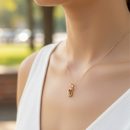 Cuello de modelo usando una cadena con un dije en forma de gato en oro amarillo de 18 quilates con cristales rojos de Joyería Caracas.