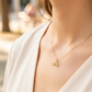 Cuello de modelo usando una cadena con un dije en forma de bicicleta en oro amarillo de 18 quilates con cristales de Joyería Caracas.