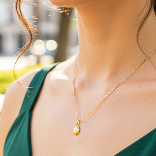 Cuello de modelo usando una cadena con un dije en forma de la Virgen de Guadalupe en oro amarillo de 18 quilates con cristales blancos de Joyería Caracas.